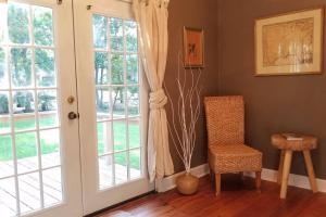 Cette chambre dispose d'une porte, d'une chaise et d'une fenêtre. dans l'établissement Historic 2-Bedroom Cloverdale Cottage, à Montgomery