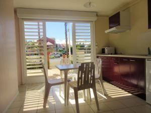 a kitchen with a table and chairs in front of a window at Studio a Le Gosier a 280 m de la plage avec jardin clos et wifi in Pointe-à-Pitre