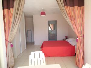 a bedroom with a red bed in a room at Studio a Le Gosier a 280 m de la plage avec jardin clos et wifi in Pointe-à-Pitre