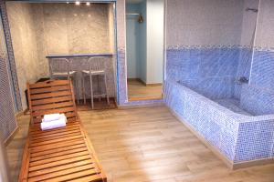 La salle de bains est pourvue d'une baignoire et d'un banc en bois. dans l'établissement Casual Civilizaciones Valencia, à Valence