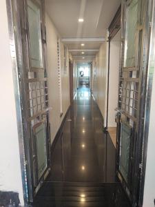 a hallway of a building with glass doors at Kamadhenu Residency Homestay & Service Apartment Coorg Madikeri in Madikeri
