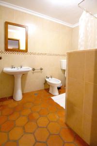 a bathroom with a sink and a toilet and a mirror at One bedroom house with lake view shared pool and furnished garden at Porto de Mos in Porto de Mós