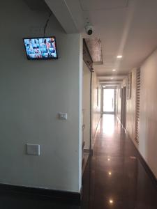 a hallway with a tv hanging on the wall at Kamadhenu Residency Homestay & Service Apartment Coorg Madikeri in Madikeri