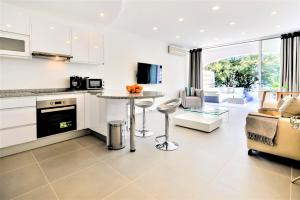 Il comprend une cuisine et un salon avec une table et des chaises. dans l'établissement Vale do Lobo Apartment B, à Vale do Lobo