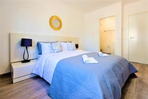 ヴァーレ・ド・ローボにあるVale do Lobo Apartment Bのベッドルーム1室(大型ベッド1台、タオル2枚付)
