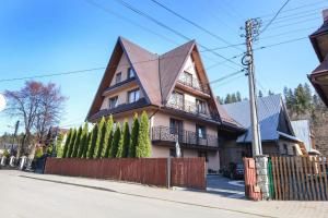 a large house with a pointed roof at Apartamenty u Burego in Biały Dunajec