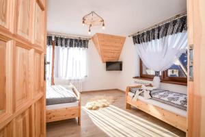 a bedroom with two beds and a window at Apartamenty u Burego in Biały Dunajec