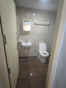 a small bathroom with a toilet and a sink at Kamadhenu Residency Homestay & Service Apartment Coorg Madikeri in Madikeri