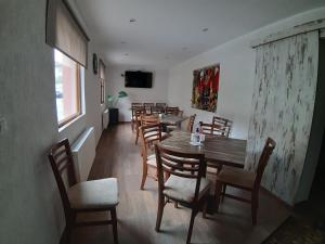 ein Esszimmer mit einem Holztisch und Stühlen in der Unterkunft Къща за гости Романс in Yagodina