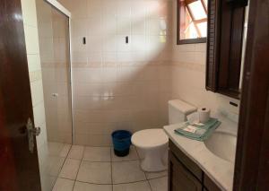 a bathroom with a toilet and a sink and a shower at Hotel Praia Bonita in Capão da Canoa
