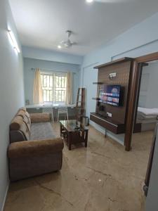 a living room with a couch and a table at Kamadhenu Residency Homestay Hotel Coorg Madikeri in Madikeri