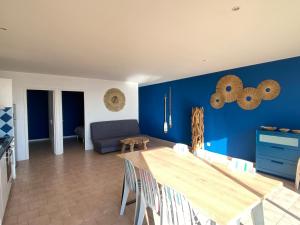 une salle à manger avec des murs bleus et une table dans l'établissement Le chant des vagues, à Frontignan