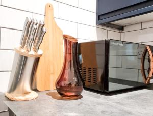 a kitchen counter with a knife block and a microwave at Spacious 3-bed near the city centre in Swansea