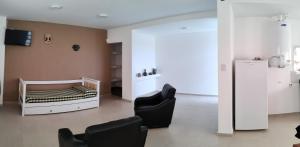 Habitación con cuna y 2 sillas en Los departamentos de Eva, en San Antonio Oeste