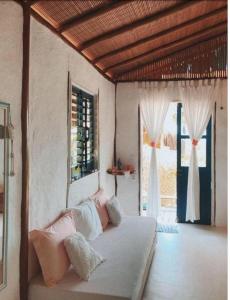 a bedroom with a bed in a room with windows at Eco-Pousada Casa Bobô in Ilha de Boipeba