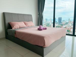 een bed met een paars knuffeldier erop bij Beacon Executive Suite by Fantabulous Guest House in George Town +30 foto's