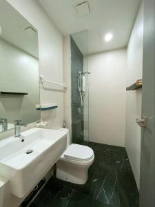 La salle de bains est pourvue d'un lavabo, de toilettes et d'un miroir. dans l'établissement Beacon Executive Suite by Fantabulous Guest House, à George Town