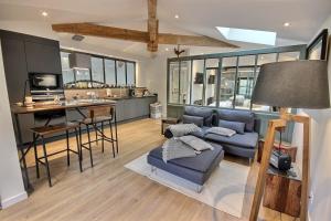 a living room with a blue couch and a kitchen at On dirait LE SUD in Andrézieux-Bouthéon