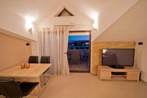 un soggiorno con TV e tavolo da pranzo di Villa Twins Markovic a Pola (Pula)
