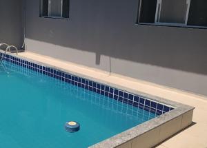 a swimming pool with a blue tile floor and a ball in it at Temporada Precisão Beta in Arraial do Cabo