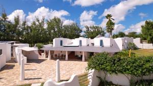 a white house with a palm tree in the background at OceanBlue Resort in Christ Church