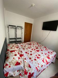 1 dormitorio con 1 cama con manta roja y blanca en Apartamento Aconchegante, en Bombinhas