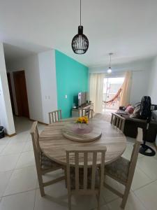 comedor con mesa de madera y sillas en Apartamento Aconchegante, en Bombinhas