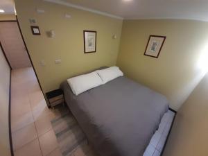 um quarto com uma cama branca num quarto em Holiday Homes Cabañas El Vergel em Osorno