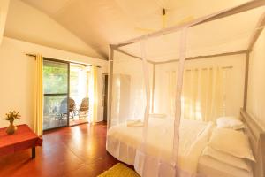 1 dormitorio con cama con dosel y balcón en DreamCatcher Unique Retreat Yoga & Spa, en Palolem