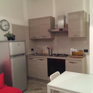 a small kitchen with a refrigerator and a sink at Centro storico, nuovo con terrazzo in Lido di Ostia