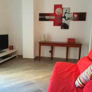 a living room with a red couch and a table at Centro storico, nuovo con terrazzo in Lido di Ostia