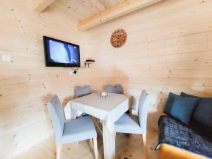 a dining room with a table and a tv on a wall at Dušan_guest_house in Kolašin +8 photos