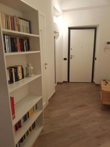 einen Flur mit Bücherregalen und eine Tür zu einem Zimmer in der Unterkunft Centro storico, nuovo con terrazzo in Lido di Ostia