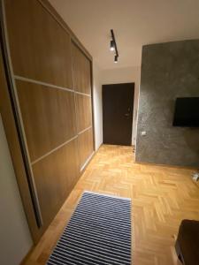Habitación con puerta corredera y suelo de madera. en My place, en Pristina