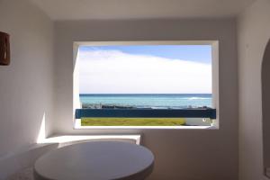 a window in a bathroom with a view of the ocean at OceanBlue Resort in Christ Church