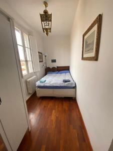 a bedroom with a bed and a wooden floor at Casa Pavó Appartamento accanto al Bargello in Florence