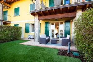 a patio with chairs in a yard at Lago di Garda a 300m - House in Manerba in Manerba del Garda