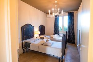 1 dormitorio con 3 camas y lámpara de araña en Lago di Garda a 300m House in Manerba, en Manerba del Garda