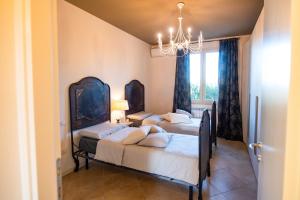 a bedroom with three beds and a chandelier at Lago di Garda a 300m - House in Manerba in Manerba del Garda +23 photos