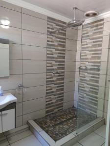 a shower with a glass door in a bathroom at Peace of Mind Holiday Home in Amanzimtoti