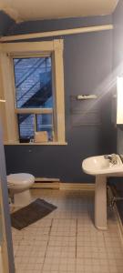 a bathroom with a toilet and a sink and a window at Zen Hostel in Toronto