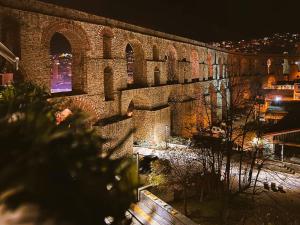 a large brick wall with arches on it at night at Under the Aqueduct boutique house in Kavála