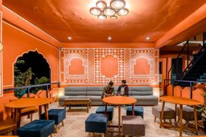 vestíbulo con sofá, mesas y sillas en Madpackers Pushkar en Pushkar