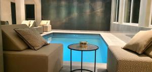 a small swimming pool with a table next to a couch at Boutique Hotel Acacia in Lovran