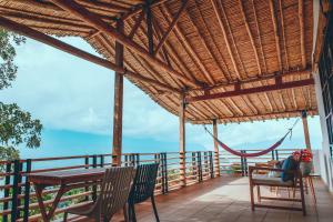 eine Terrasse mit einem Tisch, Stühlen und einer Hängematte in der Unterkunft Hotel Hacienda La Fe in Bucaramanga