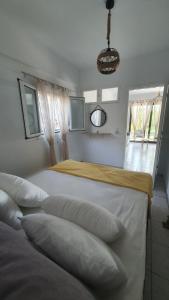 - une chambre avec un grand lit et des oreillers dans l'établissement Serenita verde Apartment, à Poros