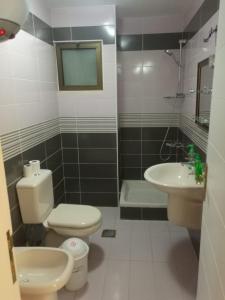 La salle de bains est pourvue de toilettes, d'un lavabo et d'une baignoire. dans l'établissement Dream Home, à Amman