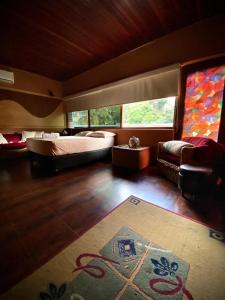 1 dormitorio con 2 camas, sofá y alfombra en Ololo Caracas, en Caracas