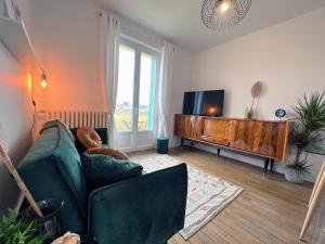 a living room with a couch and a flat screen tv at Le Sorbier, Style Appart'Hôtel, vers la gare, by PRIMO C0NCIERGERIE in Nevers +34 photos