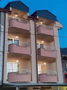 a building with balconies on the side of it at Apartmani BAKULE in Peštani